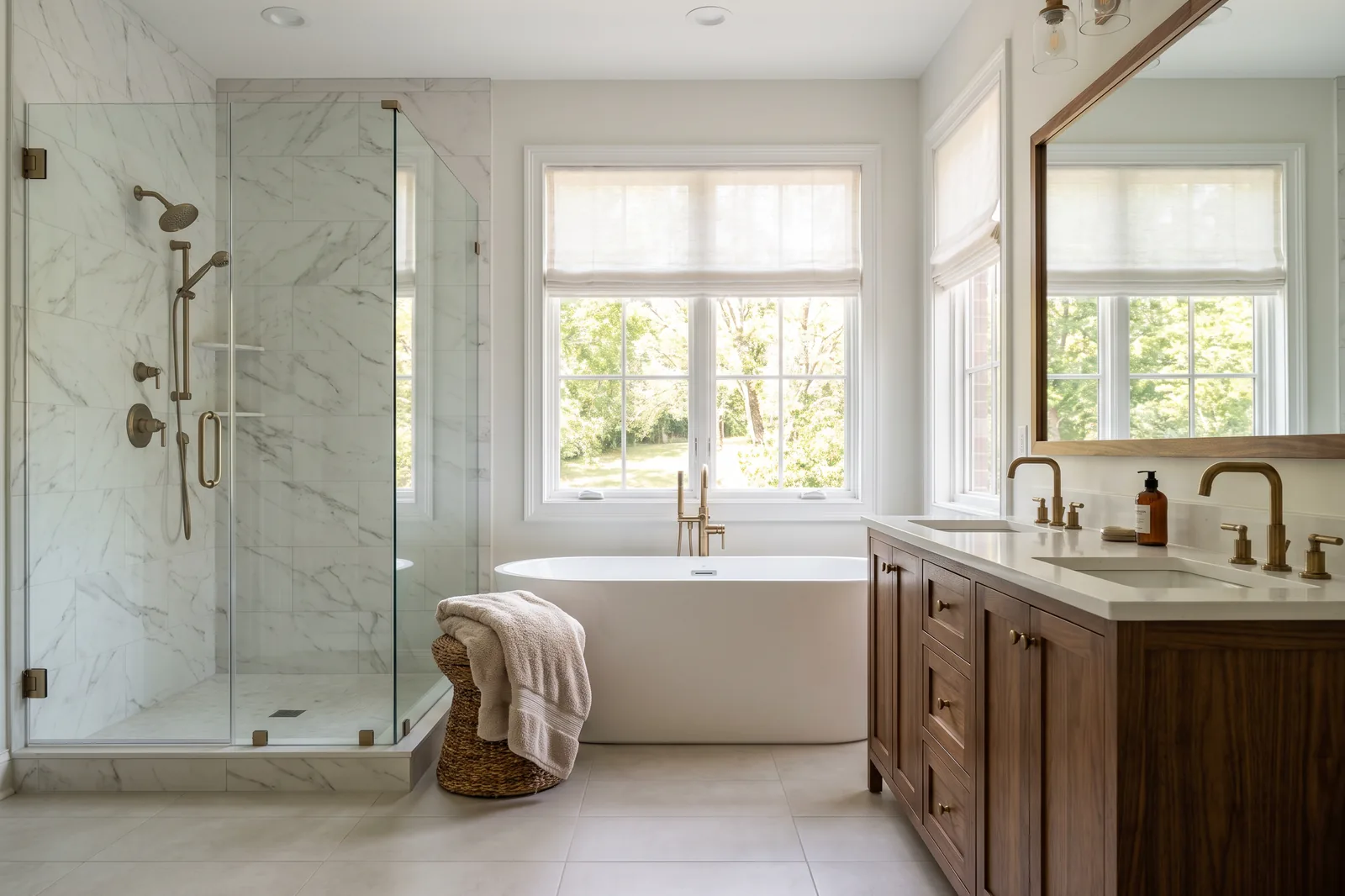 Finished primary bathroom remodel with a freestanding tub, marble-look tile shower and brushed brass fixtures